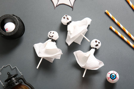 Sweet lollipops with jelly eyes and straws for Halloween party on black backgroundの写真素材