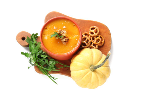 Bowl of delicious pumpkin cream soup with parsley and pretzels on white backgroundの写真素材