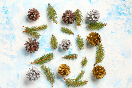 Christmas composition with pine cones and fir tree branches on light background