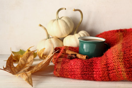 Cup of hot coffee, cinnamon and anise on warm knitted blanketの写真素材