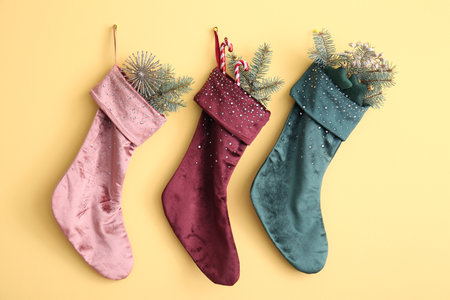 Beautiful Christmas socks with decorations hanging on yellow wallの写真素材