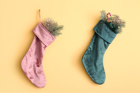 Beautiful Christmas socks with decorations hanging on yellow wallの写真素材
