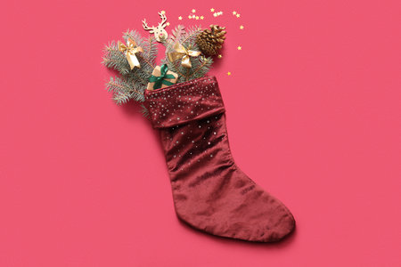 Beautiful Christmas sock with gift box and decorations on red backgroundの写真素材