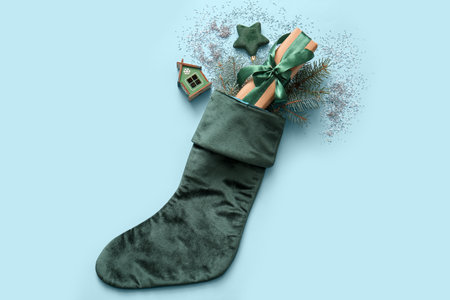 Beautiful Christmas sock with gift box and decorations on blue backgroundの写真素材
