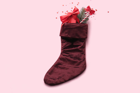 Beautiful Christmas sock with gift box and decorations on pink backgroundの写真素材