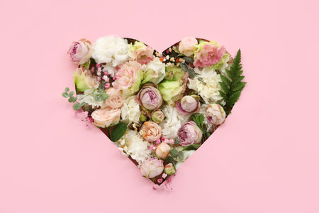 Cut pink paper in shape of heart with flowers, top view