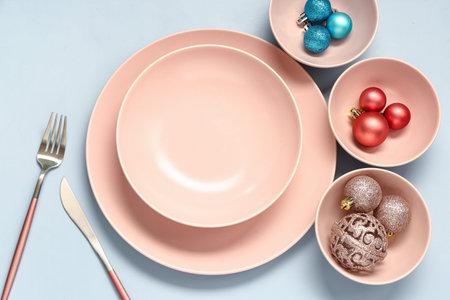 Beautiful table setting with different Christmas balls on blue background