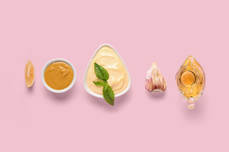 Bowl of fresh mayonnaise and ingredients on pink background