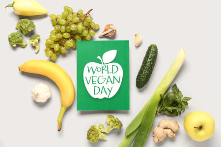 Card with text WORLD VEGAN DAY, fresh fruits and vegetables on white backgroundの写真素材