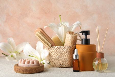 Composition with different bath supplies and beautiful lily flowers on light tableの写真素材