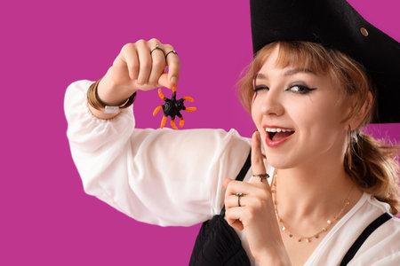 Young woman dressed for Halloween as pirate with jelly spider showing silence gesture on purple background, closeupの写真素材