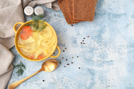 Pot of tasty chicken soup and bread on blue backgroundの写真素材