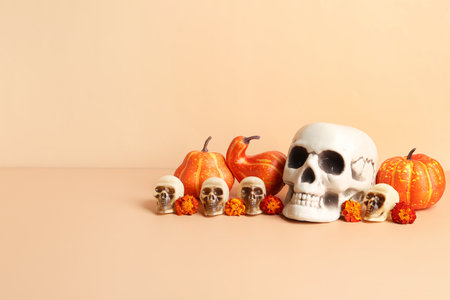 Human skulls with marigold flowers and pumpkins on orange backgroundの写真素材