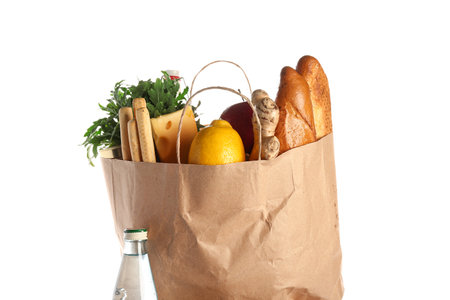 Paper bag full of food and bottle of water on white backgroundの写真素材
