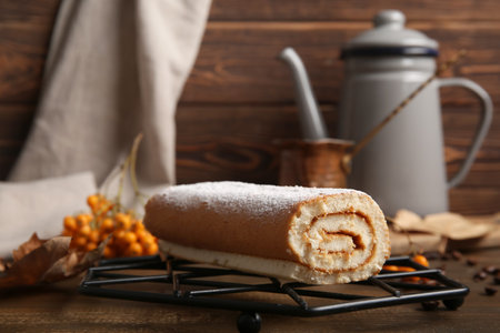 Grid with sweet sponge cake roll on wooden backgroundの写真素材