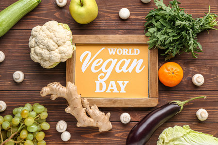 Board with text WORLD VEGAN DAY and different fresh vegetables on wooden backgroundの写真素材