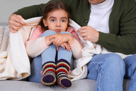 Frozen little girl and her father with lack of heating at homeの写真素材