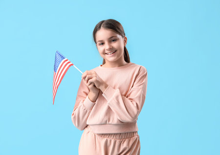 Little girl with USA flag on blue background. Veterans Day celebrationの写真素材