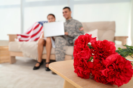 Carnation flowers on table in room, closeup. Veterans Day celebrationの写真素材