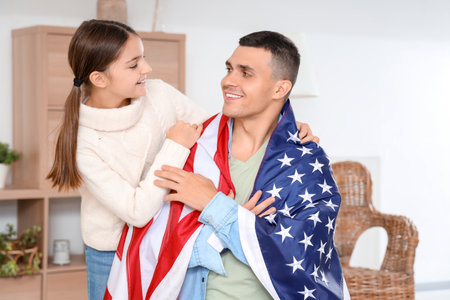 Little girl and her father with USA flag at home. Veterans Day celebrationの写真素材