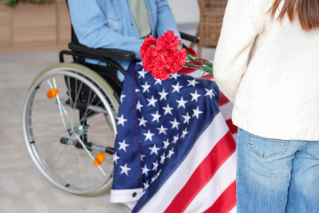 Little girl with flowers and her father at home, closeup. Veterans Day celebrationの写真素材