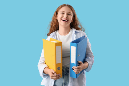 Young woman with document folders on blue backgroundの写真素材