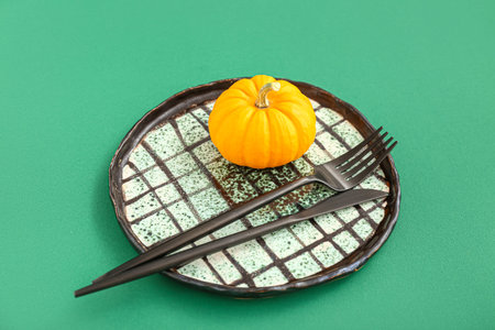 Autumn table setting with pumpkin on green background