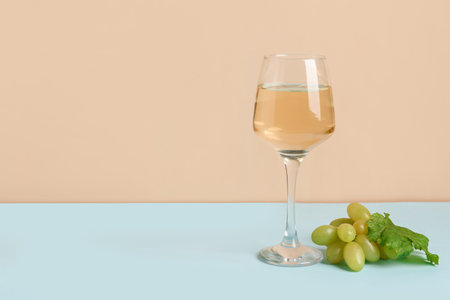 Grapes and glass of wine on color backgroundの写真素材