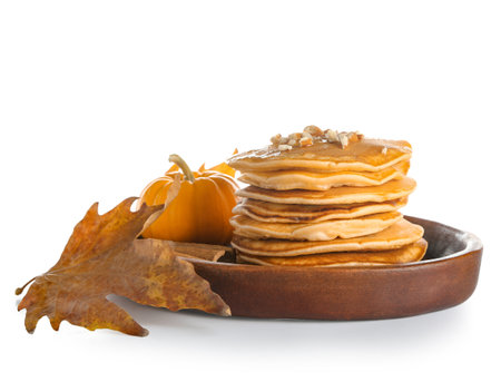 Plate of tasty pumpkin pancakes with honey, nuts and cinnamon on white backgroundの写真素材