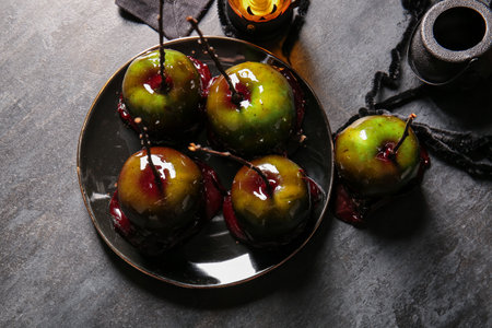 Plate of tasty caramel apples for Halloween on black backgroundの写真素材
