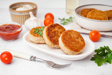 Plate of tasty meat cutlets on white background