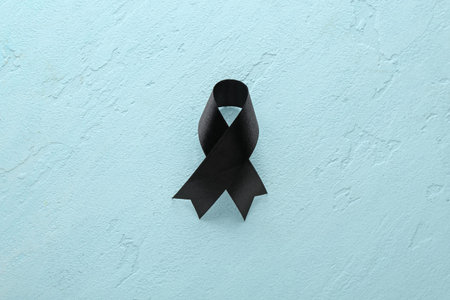 Black funeral ribbon on blue background