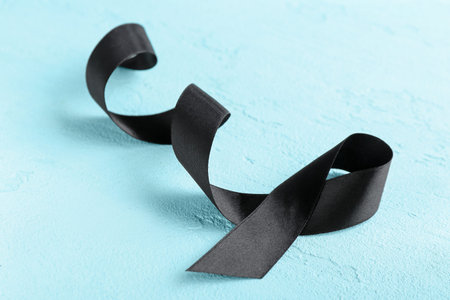 Black funeral ribbon on blue background
