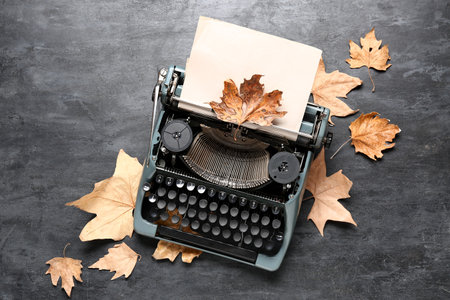 Vintage typewriter and autumn leaves on black backgroundの写真素材
