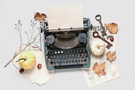 Vintage typewriter, autumn leaves, pumpkins and keys on white backgroundの写真素材