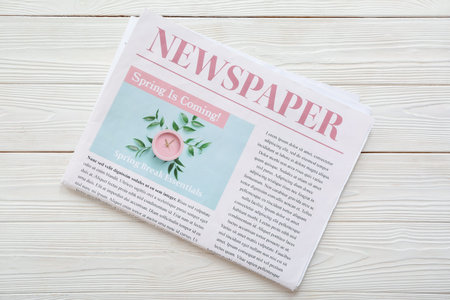 Morning newspaper on white wooden background