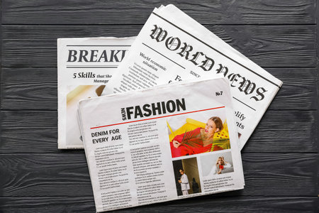 Morning newspapers on black wooden background