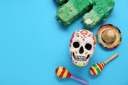 Painted human skull for Mexico's Day of the Dead (El Dia de Muertos), maracas, sombrero and pinata on blue backgroundの写真素材
