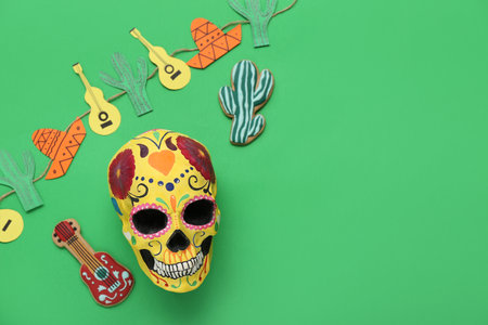 Painted human skull for Mexico's Day of the Dead (El Dia de Muertos) with decorative cacti and guitars on green backgroundの写真素材