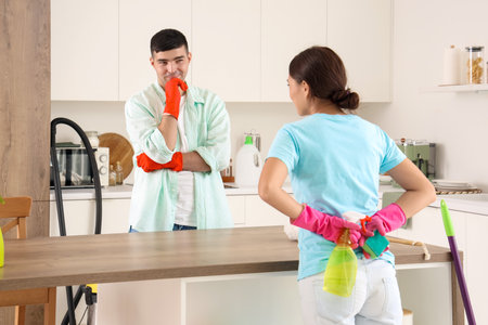 Happy young couple cleaning in kitchenの写真素材
