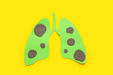 Paper lungs with tumors on yellow background. Lung cancer conceptの写真素材