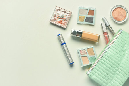 Bag with decorative cosmetic products on light background