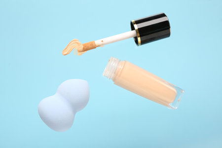 Makeup sponge and liquid foundation flying on color backgroundの写真素材