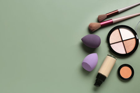 Set of decorative cosmetics and makeup accessories on green backgroundの写真素材