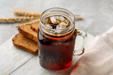 Mason jar of tasty kvass on gray background