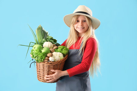 Little farmer with fresh food on blue backgroundの写真素材