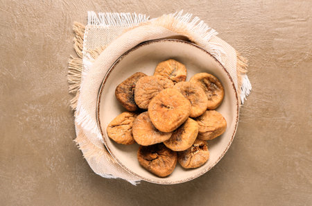 Bowl with sweet dried figs on brown backgroundの写真素材