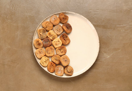 Plate with sweet dried figs on brown backgroundの写真素材