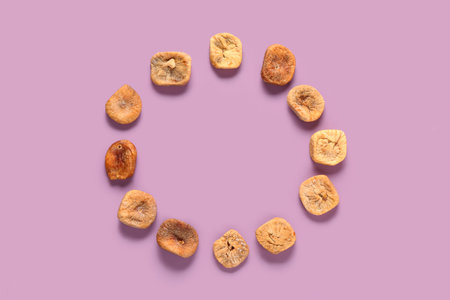 Frame made of sweet dried figs on purple background