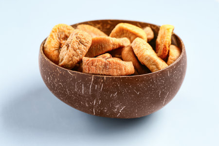 Bowl with sweet dried figs on blue backgroundの写真素材